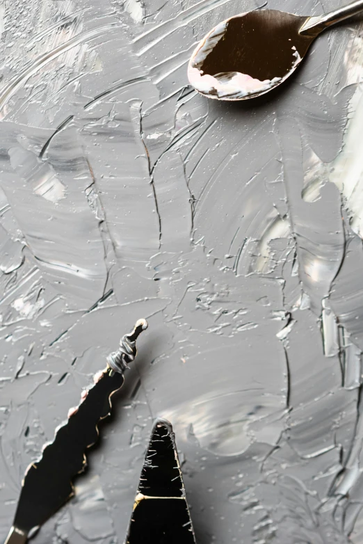 a couple of spoons sitting on top of a table, a detailed painting, inspired by Antoni Tàpies, trending on pexels, arbeitsrat für kunst, grey color scheme, detail acrylic palette knife, shattered abstractions, detailed product image