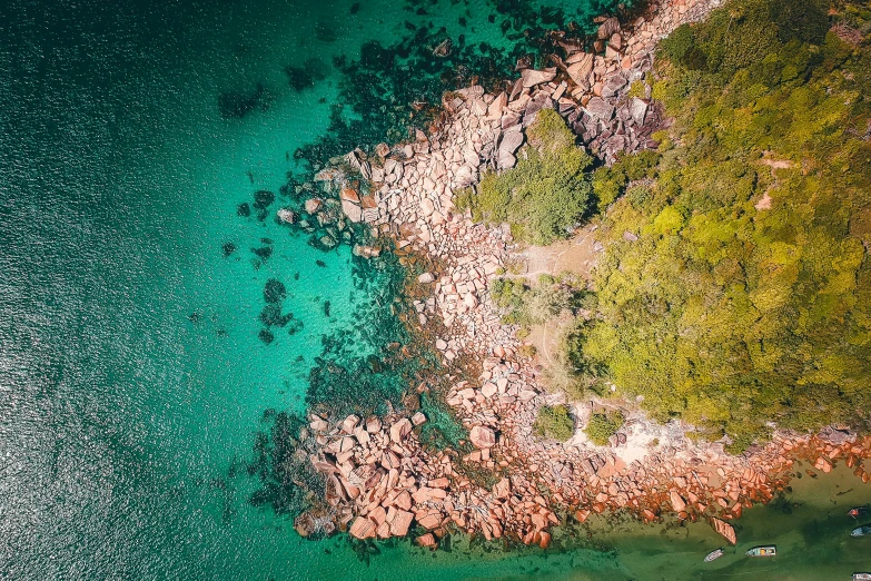 an aerial view of a body of water, a screenshot, pexels contest winner, orange rocks, manly, lush surroundings, istock