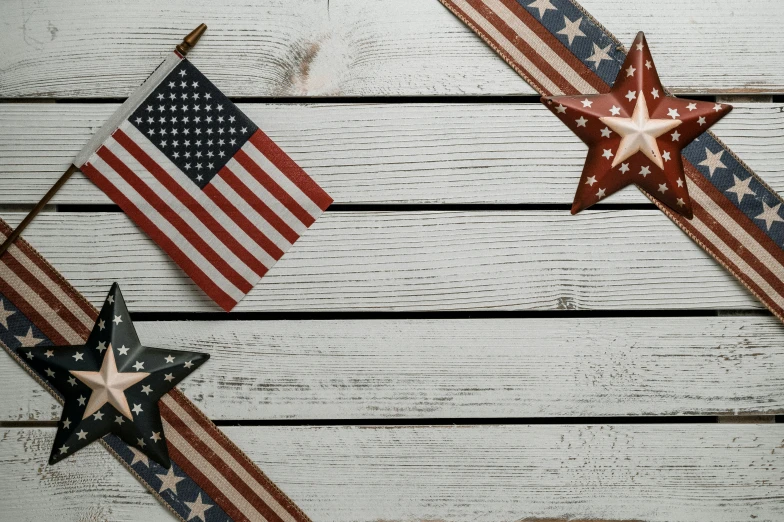 two red, white and blue stars hanging on a wooden wall, by Carey Morris, pexels contest winner, on a white table, flags, background image, enamel