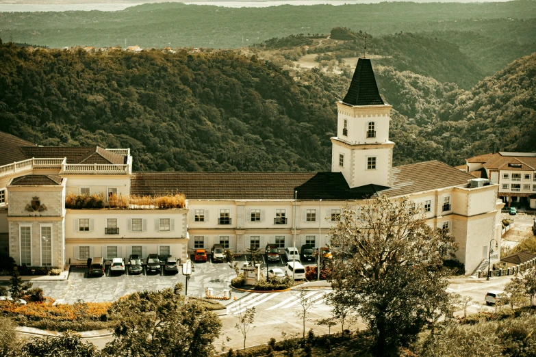 a large white building sitting on top of a lush green hillside, pexels contest winner, french village exterior, private school, gif, gui guimaraes