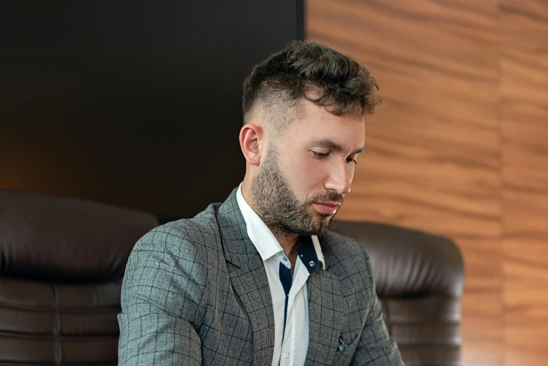 a man sitting in a chair using a laptop, a portrait, by Adam Marczyński, pexels contest winner, hurufiyya, wearing a suit, profile image, thumbnail, instagram picture