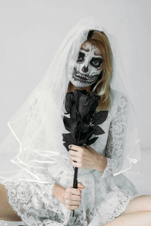 a woman dressed as a skeleton with a rose in her hand, pexels contest winner, white transparent veil, on a white table, 2b, bouquet