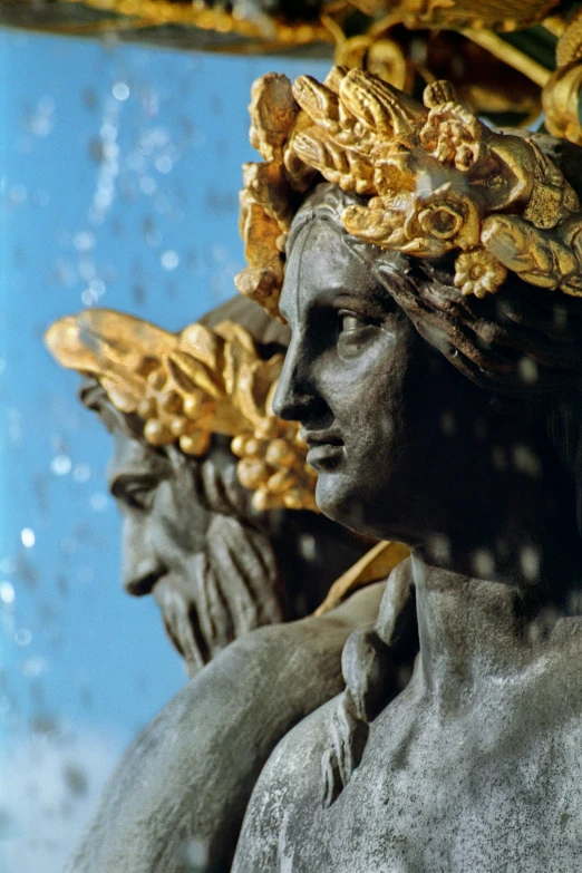 a statue of a woman with a crown on her head, an art deco sculpture, inspired by Andrea del Verrocchio, neoclassicism, gold refractions off water, two heads, 3 nymphs circling a fountain, close - up photograph