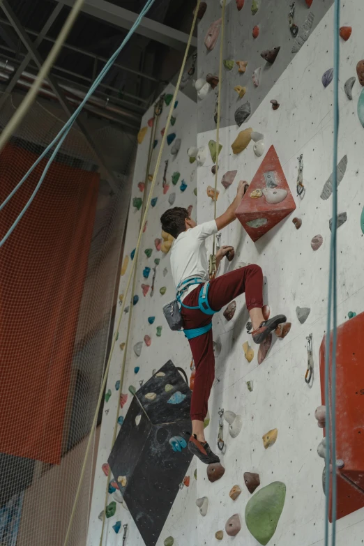 a man climbing up the side of a rock wall, happening, central hub, non-binary, white cyc, instagram story