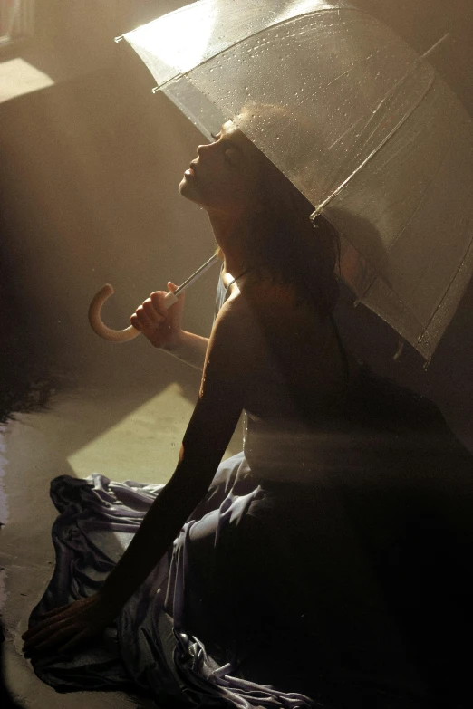 a woman sitting on the ground holding an umbrella, inspired by Brooke Shaden, window light, film still of gal gadot, concert, in ecstasy