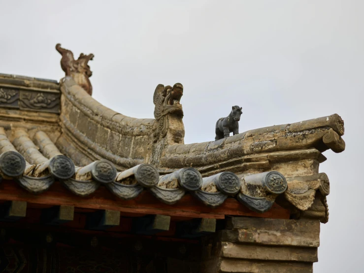 a couple of birds sitting on top of a roof, a statue, inspired by An Zhengwen, pexels contest winner, highly detailed stonework, baotou china, simple gable roofs, raccoon on roof