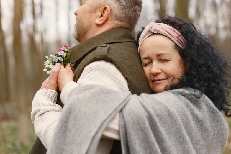 a man and woman hugging each other in the woods, pexels, renaissance, walk in a funeral procession, hygge, flowers around, profile image