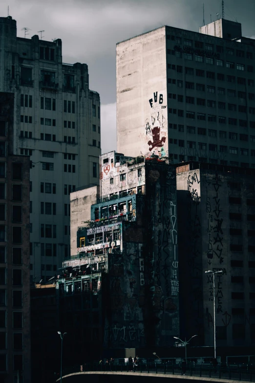 a group of tall buildings sitting next to each other, a matte painting, inspired by Elsa Bleda, pexels contest winner, brutalism, abandoned city with graffiti, sao paulo in the year 2 0 7 0, brutal archi, abstract facades of buildings