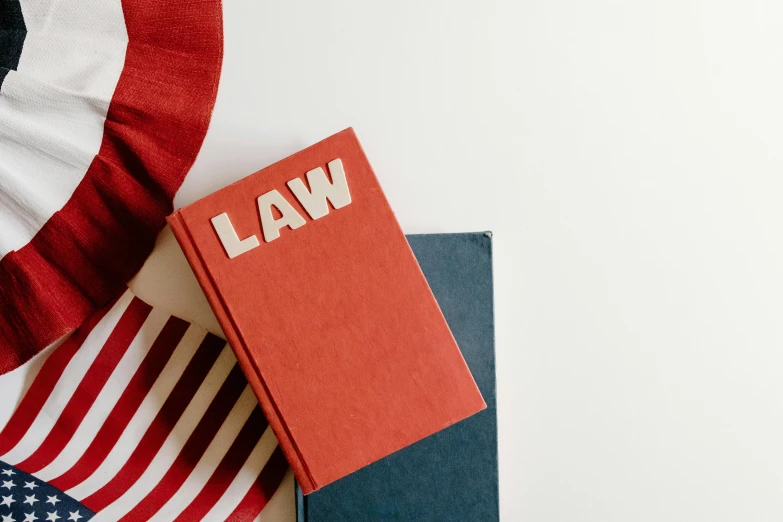 a book sitting on top of a table next to an american flag, lawyer clothing, red pennants, thumbnail, unblur