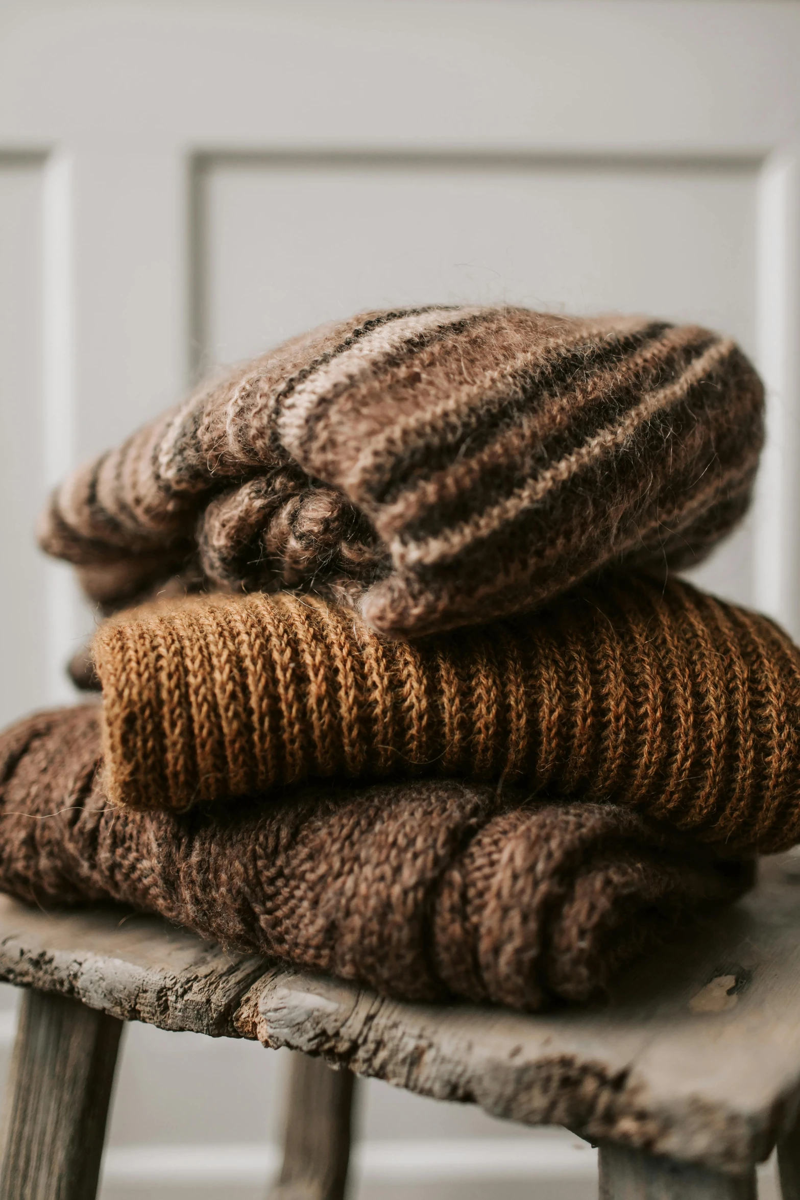 a stack of sweaters sitting on top of a wooden stool, chocolate. rugged, mocha swirl color scheme, uncrop, farms
