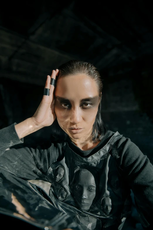 a woman sitting in a chair with her hand on her head, an album cover, antipodeans, wearing techwear and armor, large eyebrows, unfinished, 2019 trending photo