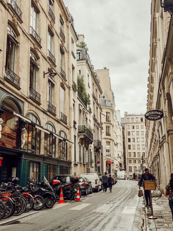 a group of people walking down a street next to tall buildings, pexels contest winner, paris school, profile image, narrow and winding cozy streets, photo of penelope cruz, 🦩🪐🐞👩🏻🦳