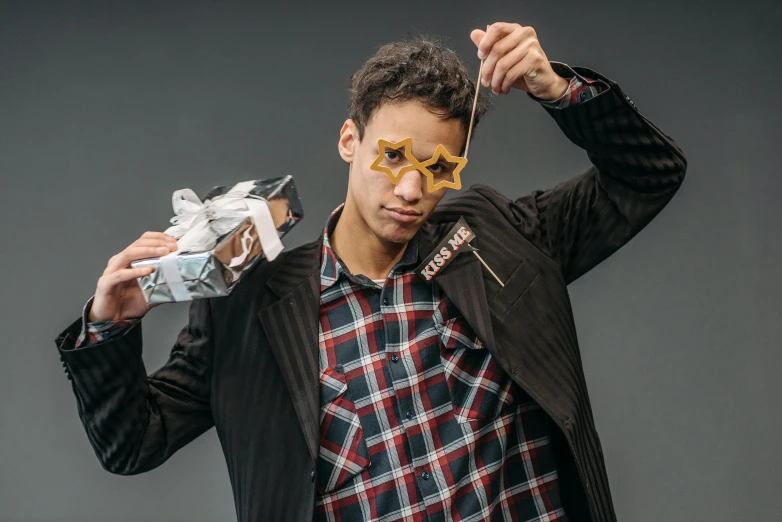 a man holding a pair of scissors over his face, an album cover, pexels contest winner, suit made of stars, cardistry, male teenager, made of cardboard