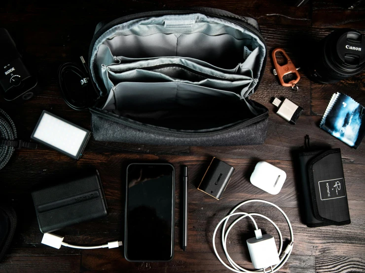 a camera bag sitting on top of a wooden table, by Carey Morris, pexels contest winner, cables and monitors, pouches, dark bacgkground, sectioned