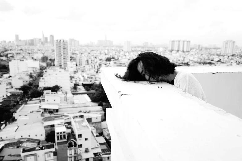 a black and white photo of a woman leaning over a ledge, by Silvia Pelissero, happening, hiding in the rooftops, ben lo, woman very tired, thanshuhai