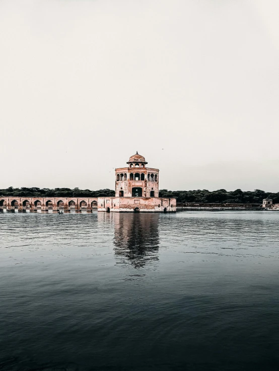 a building in the middle of a body of water, pexels contest winner, pink marble building, beautiful futuristic new delhi, grainy photo, panoramic