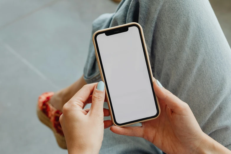 a close up of a person holding a cell phone, trending on pexels, rounded corners, wearing a cute top, white border, sitting down