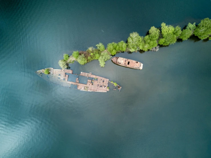 a couple of boats sitting on top of a body of water, by Adam Marczyński, pexels contest winner, environmental art, birdeye, hangzhou, sunken ship, floating trees