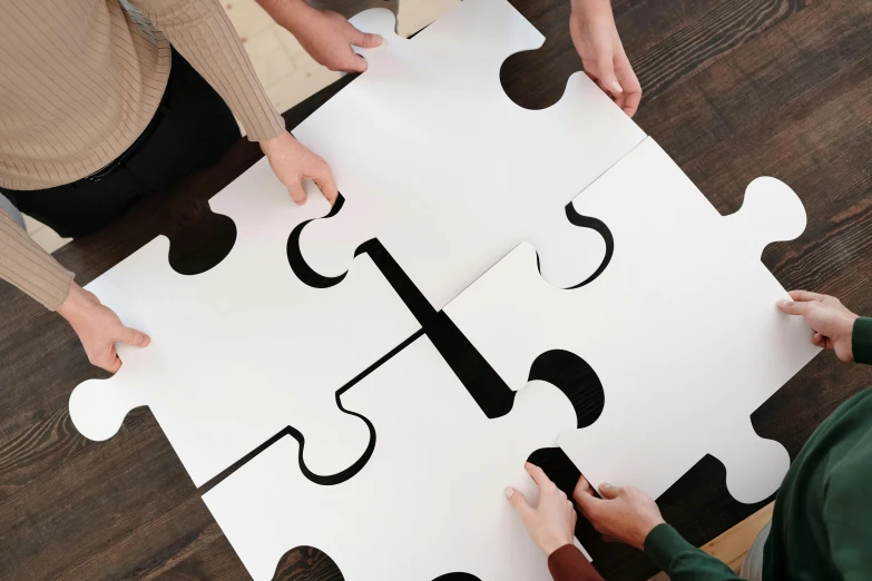 a group of people putting pieces of a puzzle together, a jigsaw puzzle, by Julia Pishtar, interactive art, white finish, penned with black on white, oversized shuriken, four