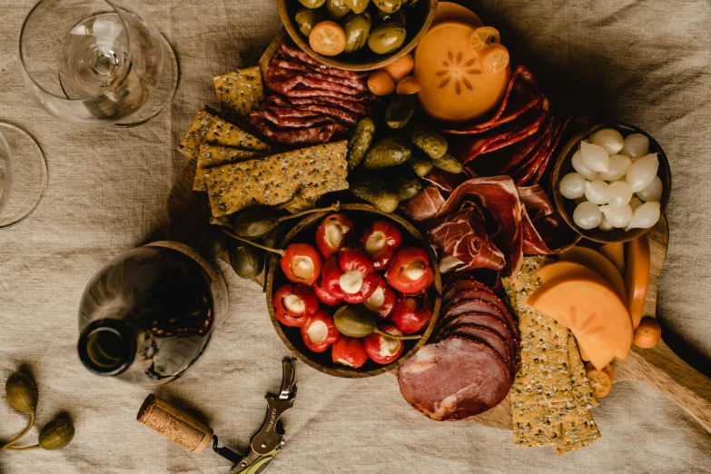 a table topped with plates of food and glasses of wine, a still life, by Carey Morris, pexels contest winner, hunting, snacks, black and terracotta, we go