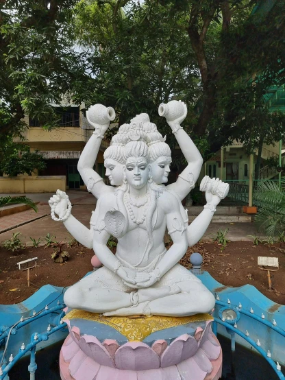 a statue of a woman sitting on top of a lotus, a statue, by Max Dauthendey, samikshavad, 3 heads, white horns, third eye in middle of forehead, taken in the early 2020s