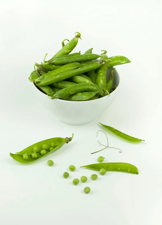 a bowl filled with green peas on top of a white table, by Ben Zoeller, pods, various posed, vanilla, heavily upvoted