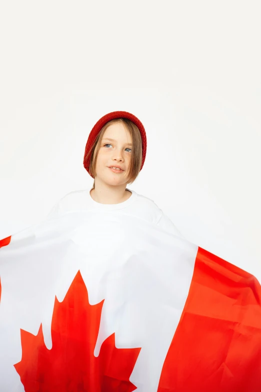 a little girl is holding a canadian flag, an album cover, shutterstock contest winner, symbolism, caps sideways, model posing, julian ope, with cape