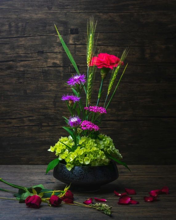 a vase filled with flowers on top of a wooden table, inspired by François Boquet, shutterstock contest winner, magical cauldron, lime and violet, carnation, bright on black