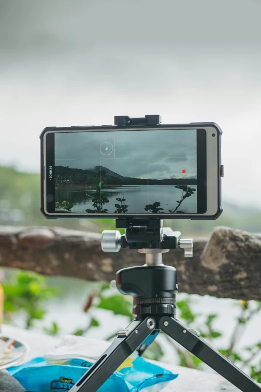 a cell phone sitting on top of a tripod, video art, sony a7, in a scenic background, mobile gimball camera, slate