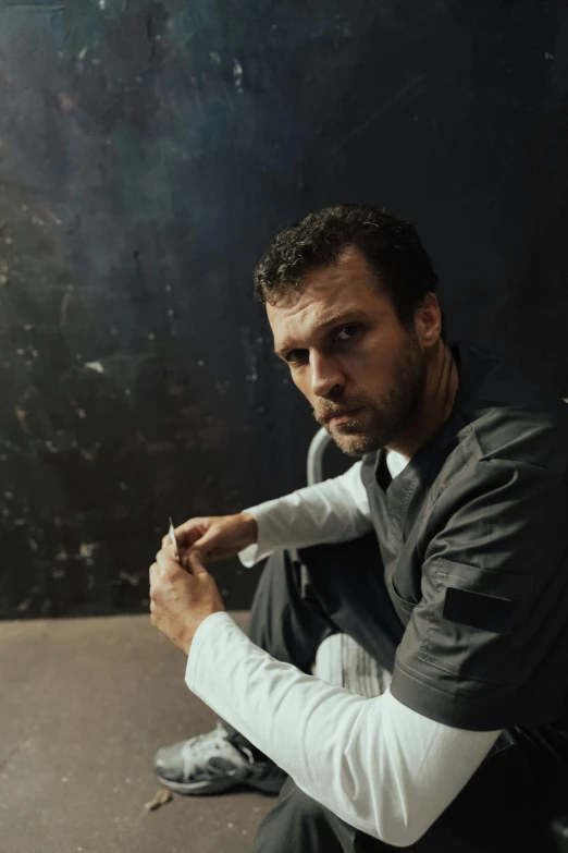 a man sitting on the ground holding a baseball bat, inspired by Joseph Morgan Henninger, unsplash, renaissance, rugged man portrait, square, dark backdrop, over his shoulder