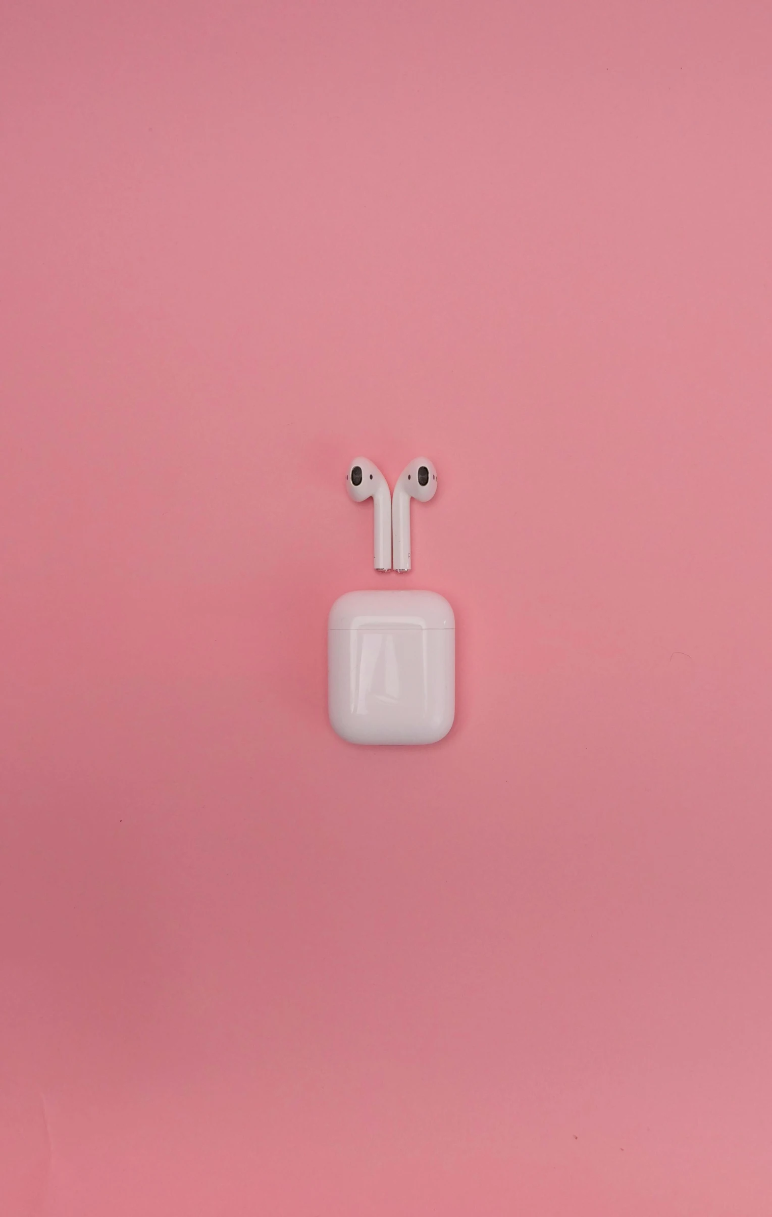 an apple airpods sitting on top of a pink surface, by Elsa Bleda, trending on pexels, 2 5 6 x 2 5 6, drone photo, - ar 1 6 : 9, earring