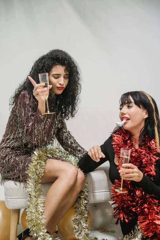 two women sitting on a couch drinking champagne, pexels, renaissance, vibrent red lipstick, doing a sassy pose, glitter gif, middle eastern