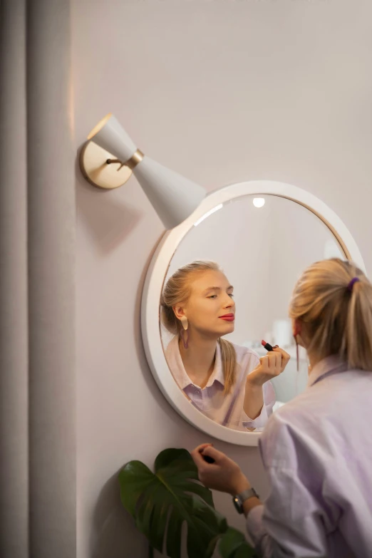 a woman brushing her teeth in front of a mirror, by Julia Pishtar, pexels contest winner, magic realism, oled lights in corners, designer product, sconces, high angle