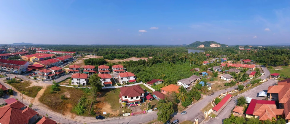 a bird's eye view of a residential area, hurufiyya, malaysia jungle, fully open sky, near a river, landscape photo