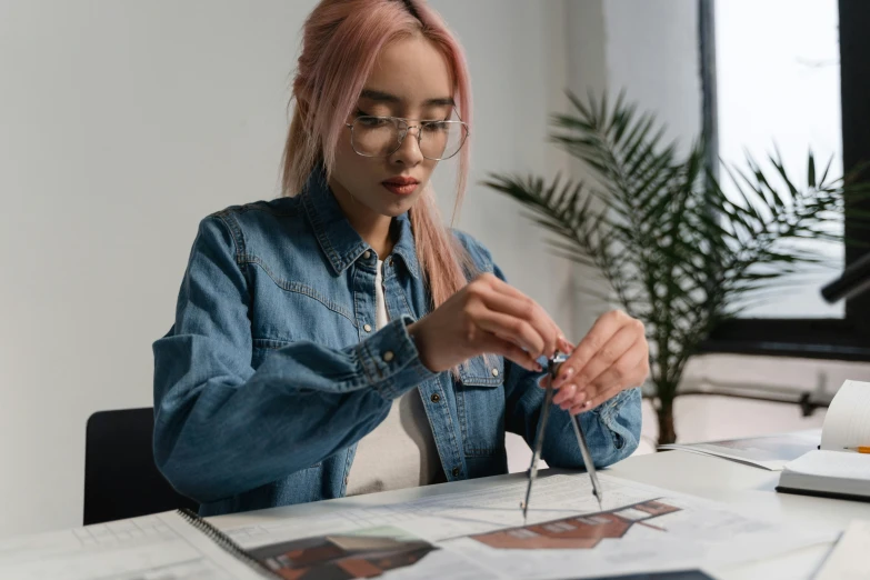 a woman sitting at a table with a pair of scissors, a photorealistic painting, trending on pexels, square rimmed glasses, technical drawings, student, fashion designer