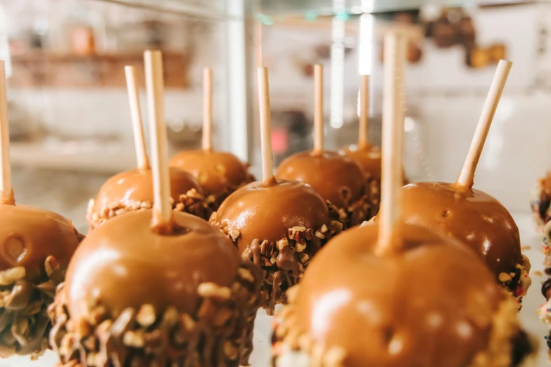 a close up of a tray of chocolate covered apples, by Emma Andijewska, trending on pexels, caramel, square, melbourne, thumbnail