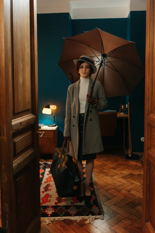 a woman standing in a doorway holding an umbrella, by Emma Andijewska, pexels contest winner, art nouveau, 1 9 2 0 s room, detective clothes, anomalisa, production photo