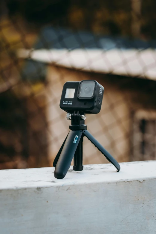 a small tripod sitting on top of a cement wall, a picture, unsplash, taken on go pro hero8, all black matte product, hero action pose, webcam