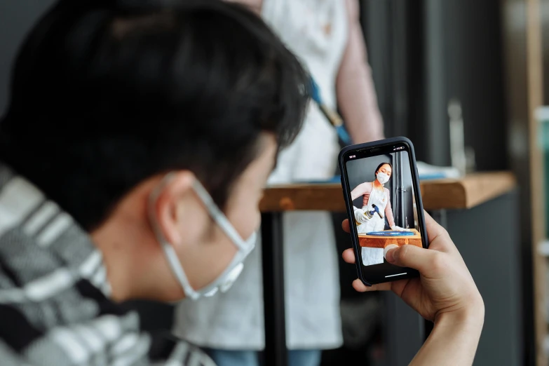 a person taking a picture with a cell phone, by Julia Pishtar, trending on pexels, hyperrealism, healthcare worker, asian male, rectangle, thumbnail