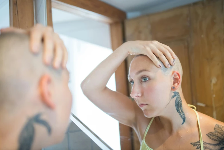 a woman that is standing in front of a mirror, by Julia Pishtar, unsplash, antipodeans, bald patch, facial tattoos, scientific photo, scratching head