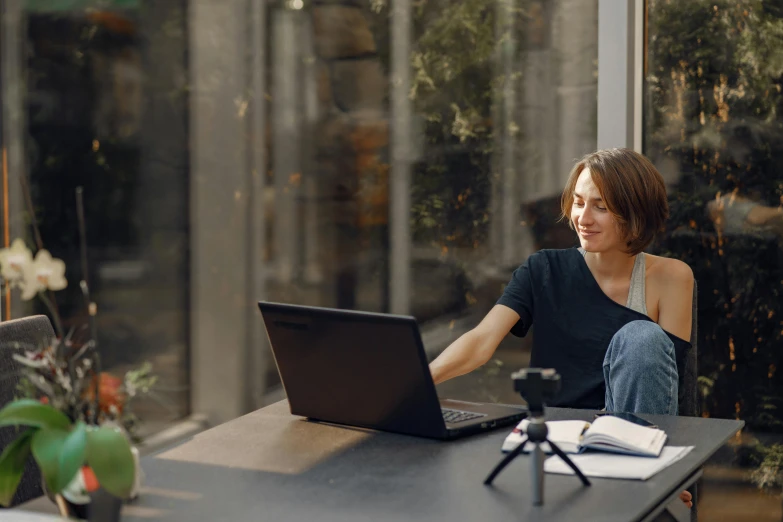 a woman sitting at a table with a laptop, pexels contest winner, happening, avatar image, worksafe. cinematic, profile image, bottom angle