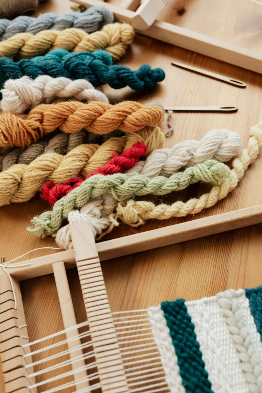 a weaving loom sitting on top of a wooden table, various colors, promotional image, hair loopies, corduroy