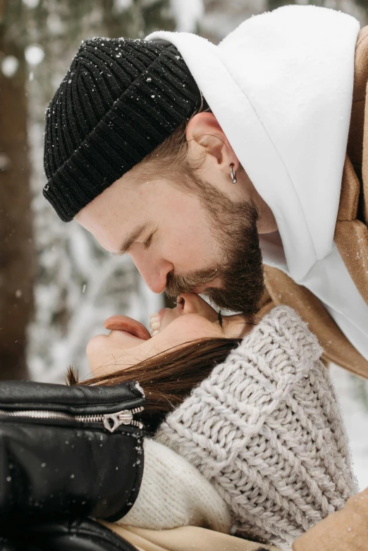 a man and a woman kissing in the snow, beard stubble, with black beanie on head, 2019 trending photo