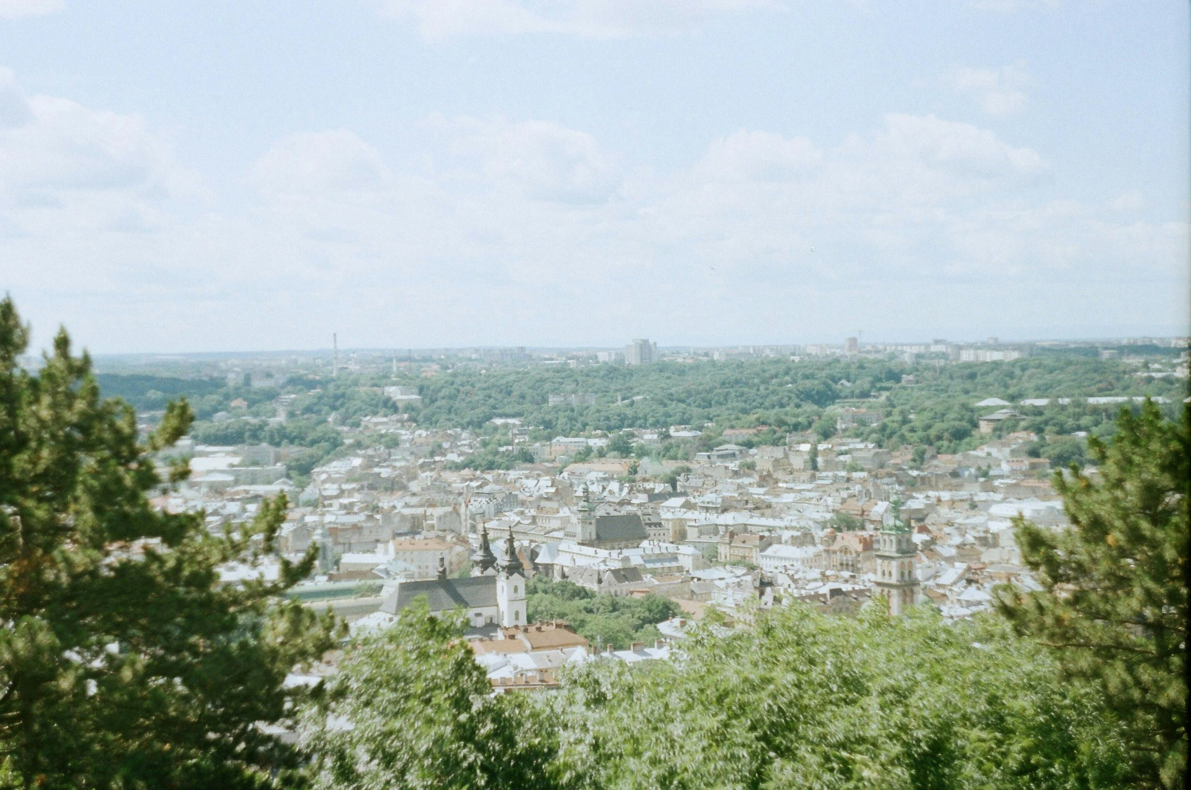 a view of a city from the top of a hill, by Emma Andijewska, unsplash, renaissance, crystal palace, shot on hasselblad, slight haze, low quality footage