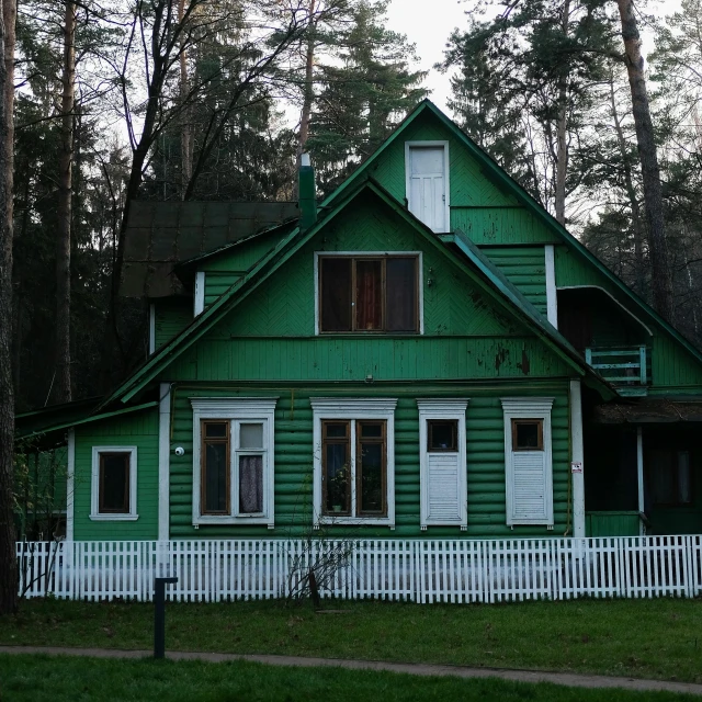a green house with a white fence in front of it, a picture, inspired by Isaac Levitan, flickr, pine forests, front face, old cabin, two stories