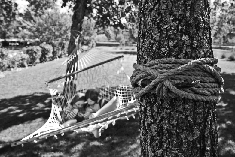 a black and white photo of a hammock tied to a tree, inspired by Sergio Larraín, girls resting, 🌸 🌼 💮, lonely family, rope