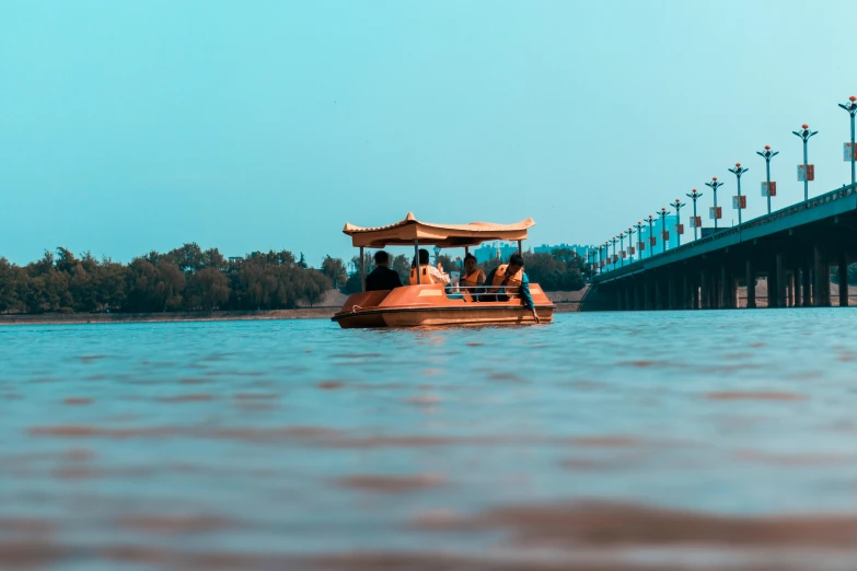 a boat on a body of water with a bridge in the background, pexels contest winner, indore, fan favorite, brown water, floating chinese lampoons