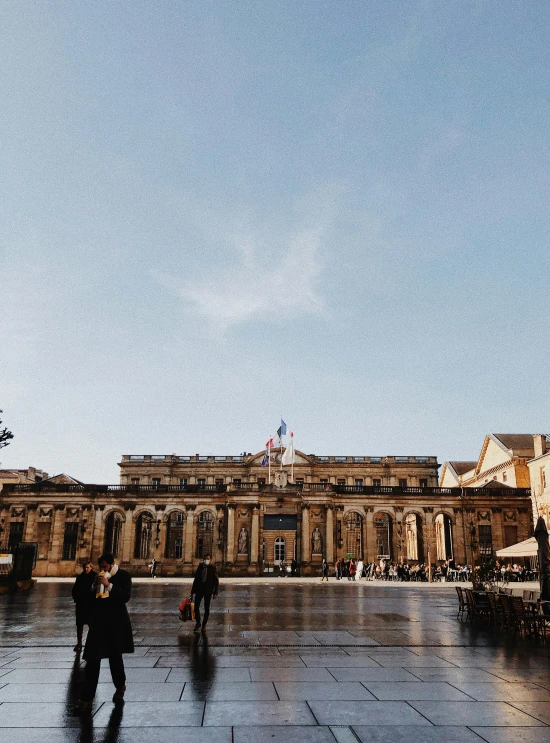 a couple of people that are standing in front of a building, by Andrée Ruellan, pexels contest winner, neoclassicism, a wide open courtyard in an epic, prefecture streets, slide show, square