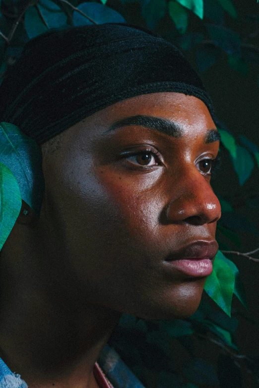 a close up of a person wearing a turban, by Cosmo Alexander, lush greens, nonbinary model, lights on, man is with black skin