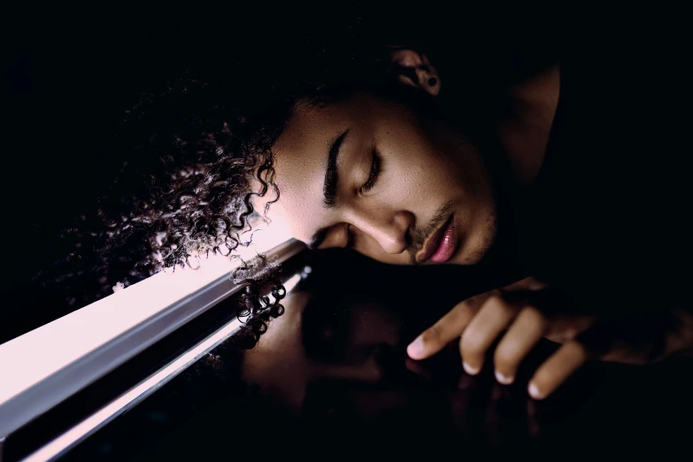 a close up of a person with a cell phone, an album cover, by Everett Warner, realism, beautiful young prince, sleeping, holding sabre, cinematic light and reflections